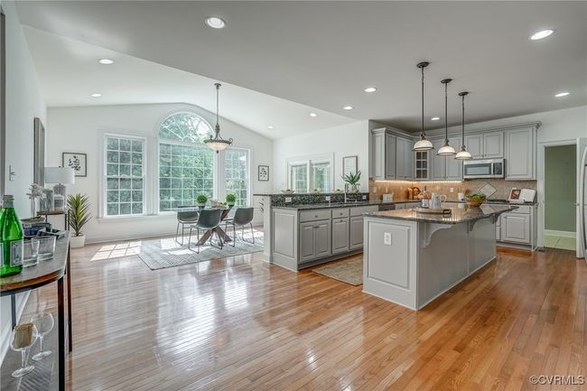 The expansive kitchen is a chef’s dream, featuring granite countertops, a large center island, stainless steel appliances, and ample cabinetry for storage and prep. | Image 22