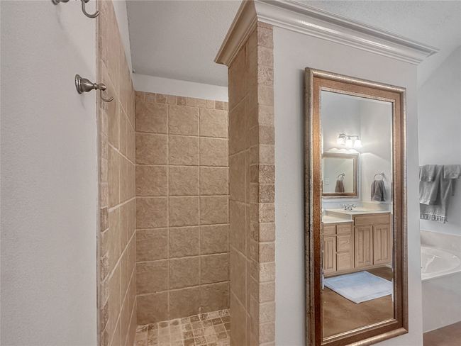 Full bath featuring a tile shower, vanity, and a tub | Image 8