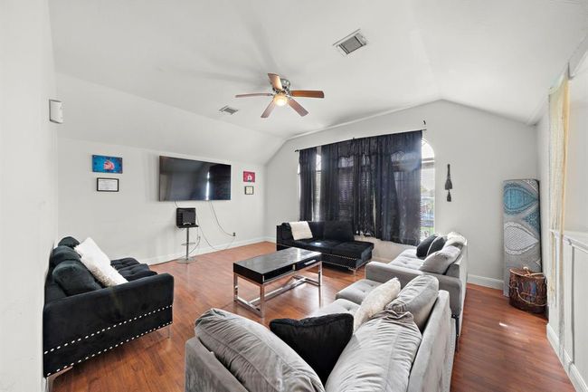 The vaulted ceiling design elevates the feel of the room, making it appear even larger while drawing in additional light from the front windows. It’s a detail that adds both functionality and charm to this flexible-use space. | Image 7