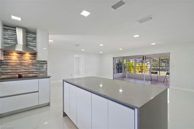 Kitchen featuring white cabinetry, modern cabinets, and wall chimney range hood | Image 9