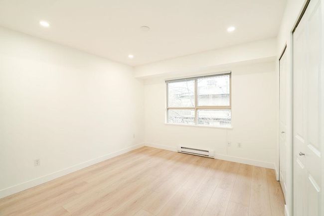 Unfurnished bedroom featuring a closet, baseboards, light wood finished floors, and baseboard heating | Image 25