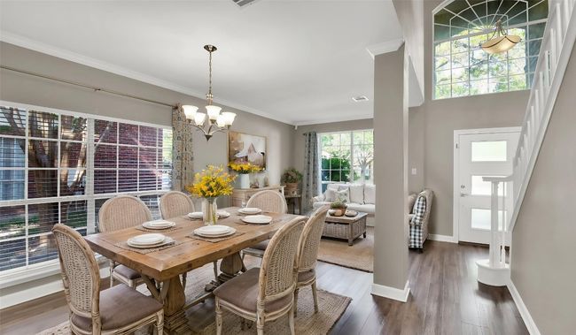 Dining space with a chandelier, crown molding, wood finished floors, and baseboards (virtually staged) | Image 4