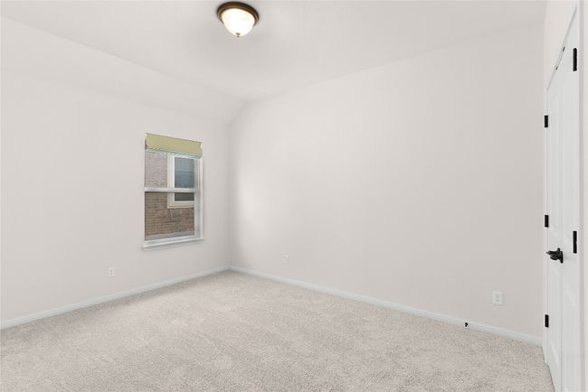 Carpeted empty room with baseboards and lofted ceiling | Image 12