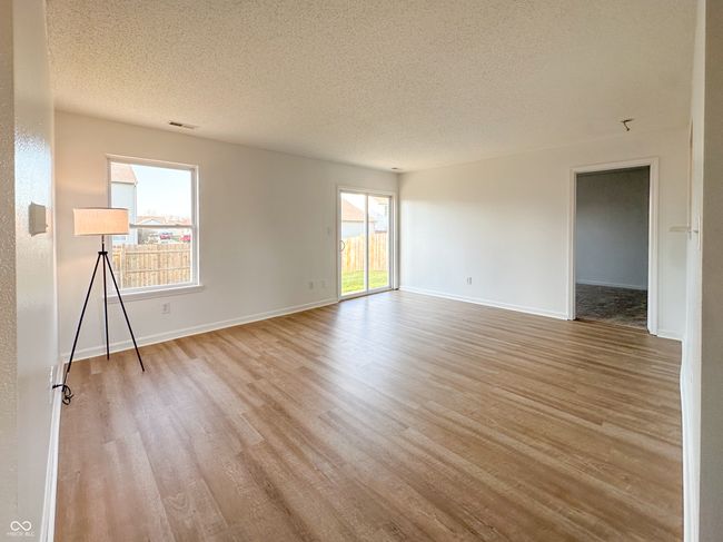 spare room with light wood-type flooring, baseboards, visible vents, and a textured ceiling | Image 10