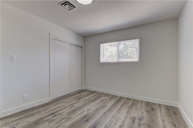 Unfurnished bedroom with light wood-type flooring, a closet, baseboards, and a textured ceiling | Image 23