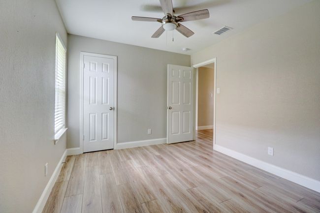 Unfurnished bedroom featuring light wood finished floors, multiple windows, ceiling fan, and a closet | Image 22