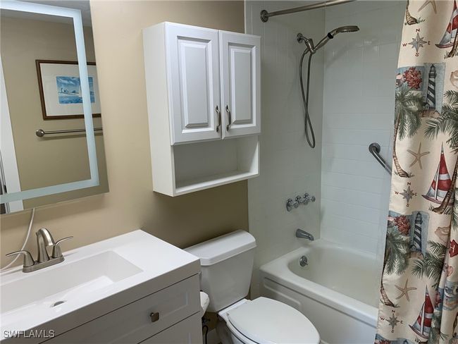 Full bathroom featuring shower / bathtub combination with curtain, vanity, and toilet | Image 13