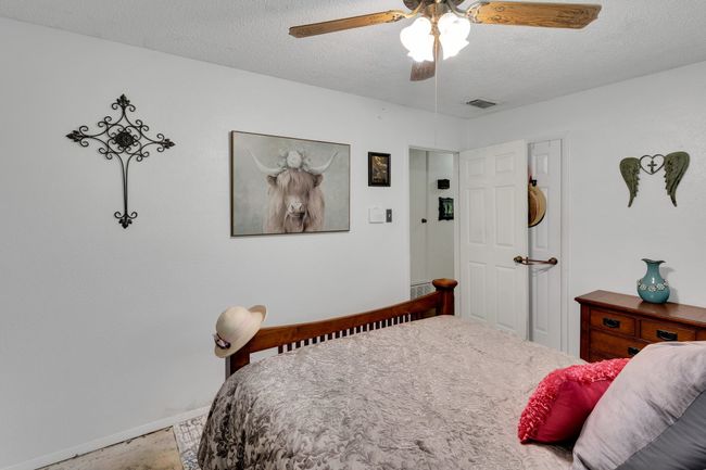 Bedroom with a textured ceiling, baseboards, and a ceiling fan | Image 13