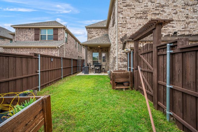 View of backyard with a fence, a gate, and a covered patio | Image 33