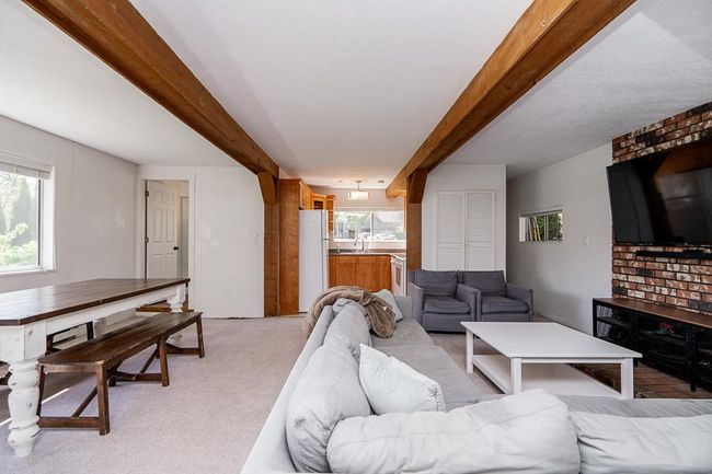 Living area featuring beam ceiling and light carpet | Image 32