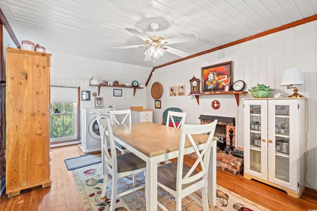 Dining area with wood ceiling, hardwood / wood-style flooring, crown molding, ceiling fan, and washer and clothes dryer | Image 9