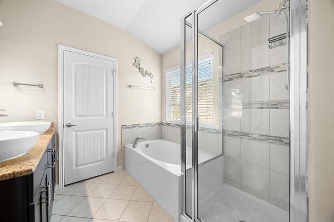 There's also a relaxing garden tub for soaking away all of your stress plus a separate shower with tasteful tile backsplash. | Image 20