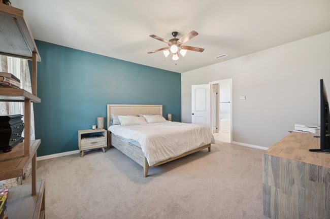Primary bedroom featuring a ceiling fan and connected bathroom | Image 9