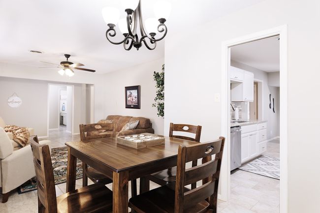 Dining room featuring visible vents, baseboards, and ceiling fan with notable chandelier | Image 9