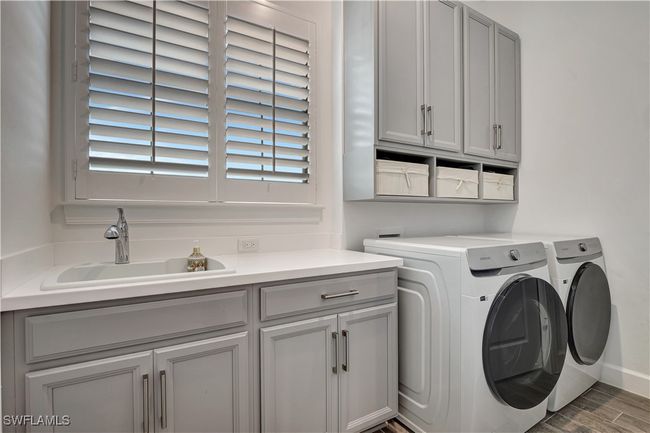 Features washer, dryer, ample wood cabinetry, and storage baskets | Image 25