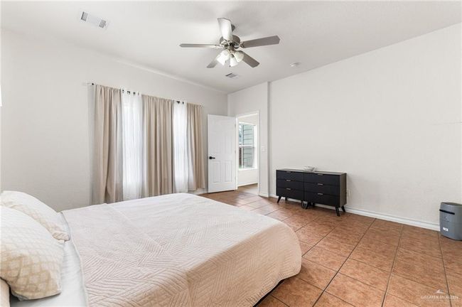 Bedroom with light tile patterned floors and ceiling fan | Image 11
