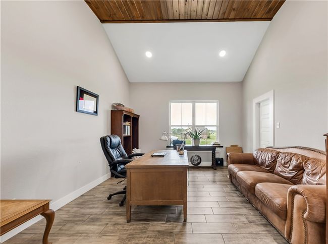 Office area with high vaulted ceiling, wood finished floors, baseboards, and recessed lighting | Image 9
