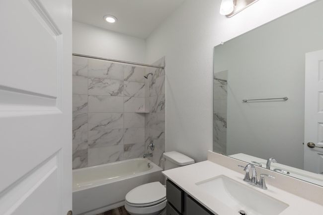 Bathroom featuring toilet, vanity, and shower / washtub combination | Image 10