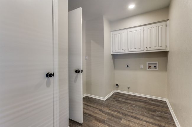 Laundry area featuring hookup for an electric dryer, washer hookup, dark wood-style floors, hookup for a gas dryer, and cabinet space | Image 23