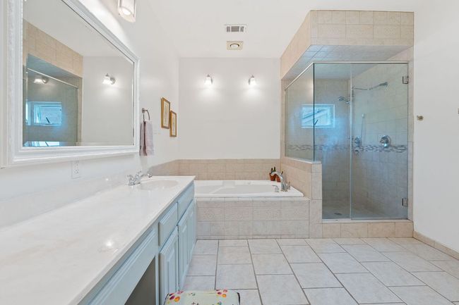 Bathroom with a garden tub, vanity, tile patterned flooring, and a shower stall | Image 21
