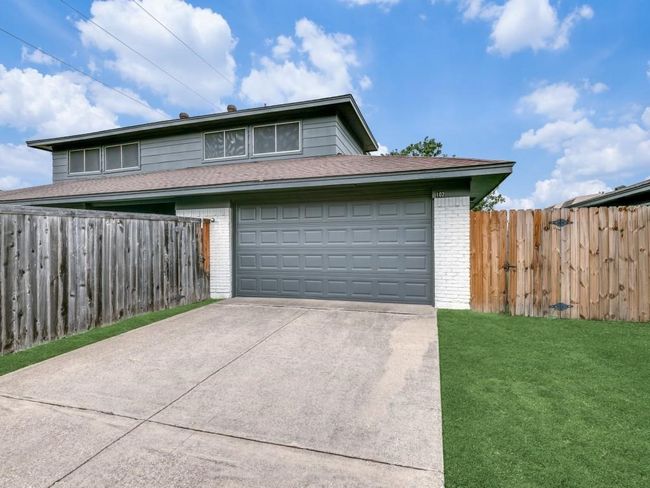 View of front facade featuring brick siding, concrete driveway, and an attached garage | Image 16