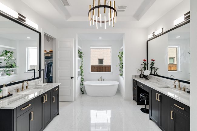 Full bath featuring a soaking tub, a tray ceiling, healthy amount of natural light, two vanities, and recessed lighting | Image 22