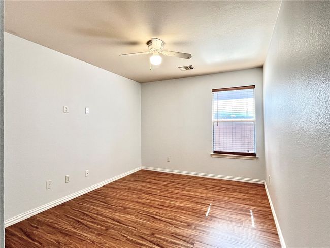 Unfurnished room featuring a ceiling fan, wood finished floors, a textured wall, and a textured ceiling | Image 30