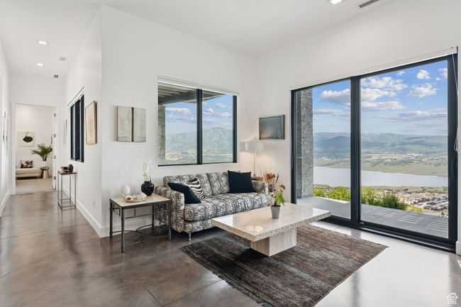 Living area featuring finished concrete floors and a water and mountain view | Image 53