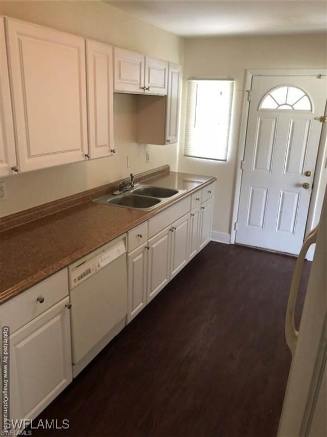 Kitchen with sink, white cabinets, dark hardwood / wood-style flooring, and white dishwasher | Image 4