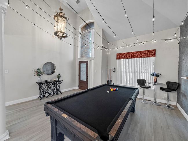 Recreation room with plenty of natural light, light wood-style flooring, baseboards, and high vaulted ceiling | Image 11