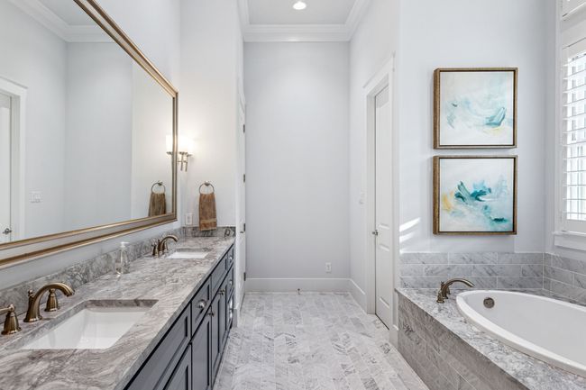 Bathroom featuring double vanity, ornamental molding, a sink, and a garden tub | Image 17