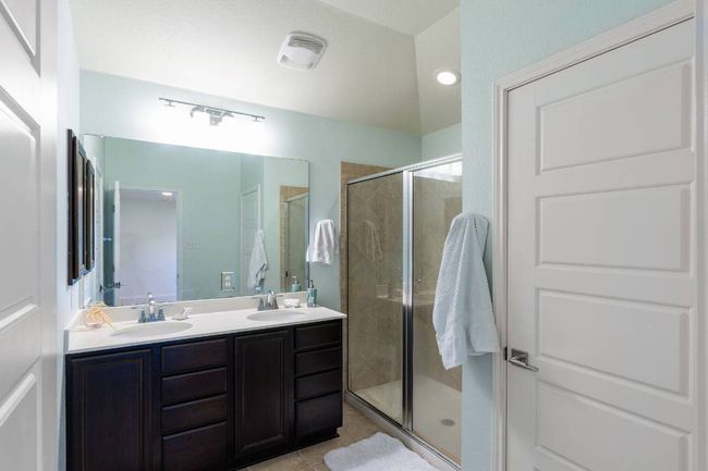 Full bathroom with a shower stall, double vanity, and tile patterned floors | Image 4