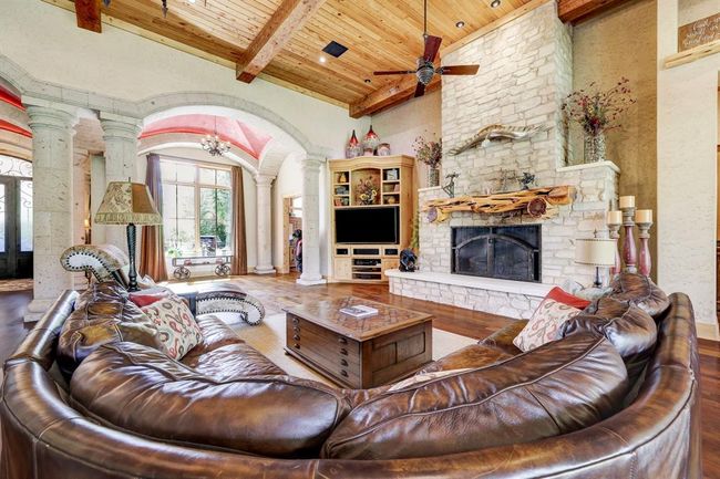 The oversized stone fireplace and cedar mantle provide a stunning focal point of the living room. | Image 13