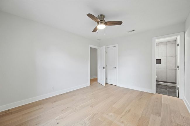 Unfurnished bedroom with light wood-type flooring, connected bathroom, and a ceiling fan | Image 21