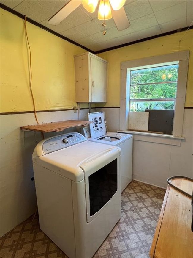 Laundry area featuring separate washer and dryer, cabinets, ceiling fan, and light tile floors | Image 17