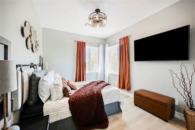 Bedroom with light wood-style floors, baseboards, and a notable chandelier | Image 42
