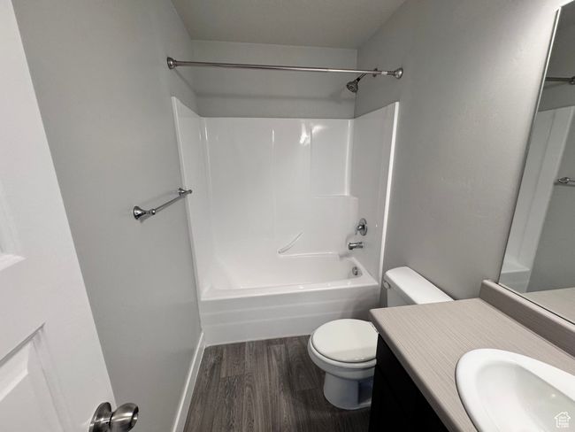 Bathroom with vanity, shower / bathtub combination, toilet, baseboards, and wood finished floors | Image 22