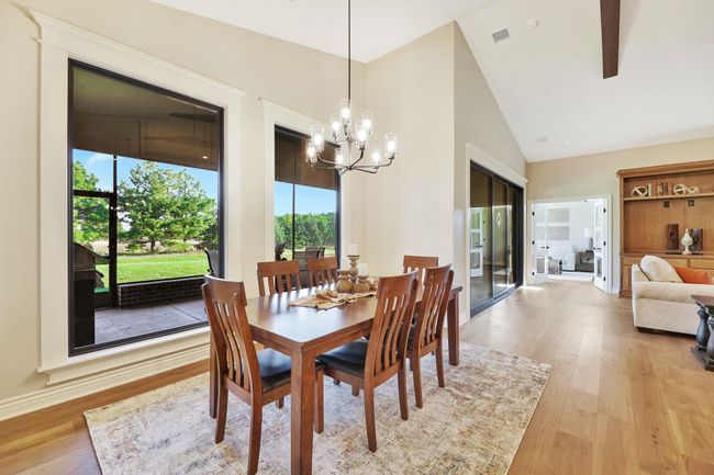 Dining area featuring light hardwood / wood-style flooring, a chandelier, and high vaulted ceiling | Image 16