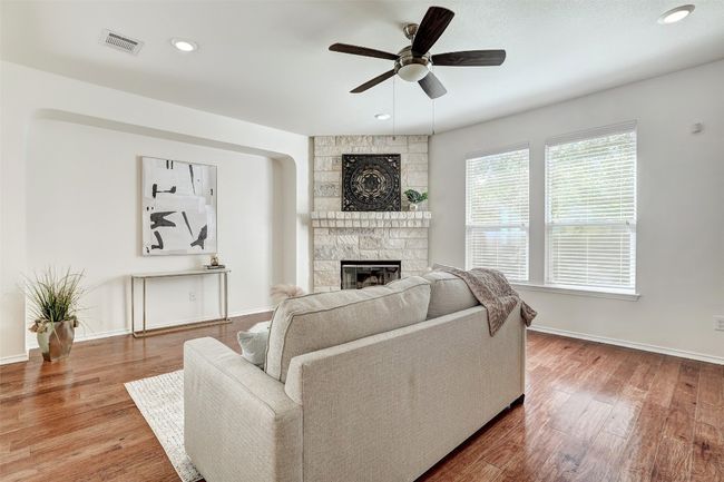Living room featuring a stone fireplace, ceiling fan | Image 12