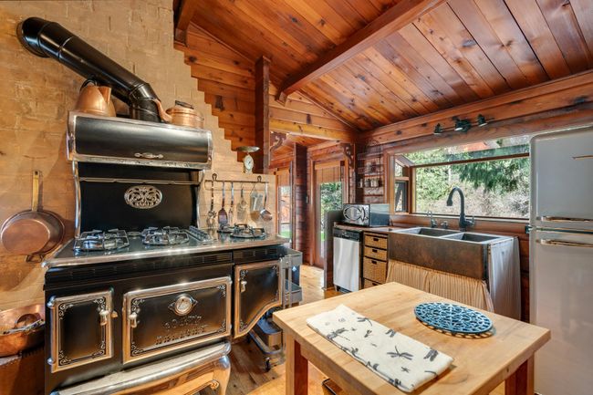 Kitchen featuring wooden ceiling, stainless steel dishwasher, freestanding refrigerator, and light wood finished floors | Image 12