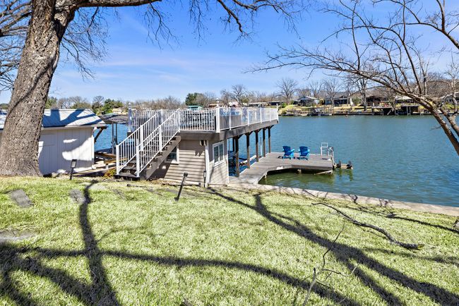 View of dock featuring stairway, a yard, and a water view | Image 18