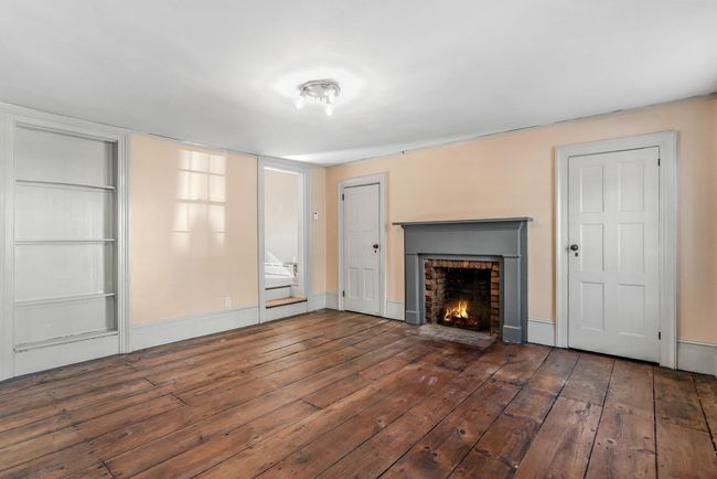 Unfurnished view of space, far corner has entry to additional large room. | Image 9