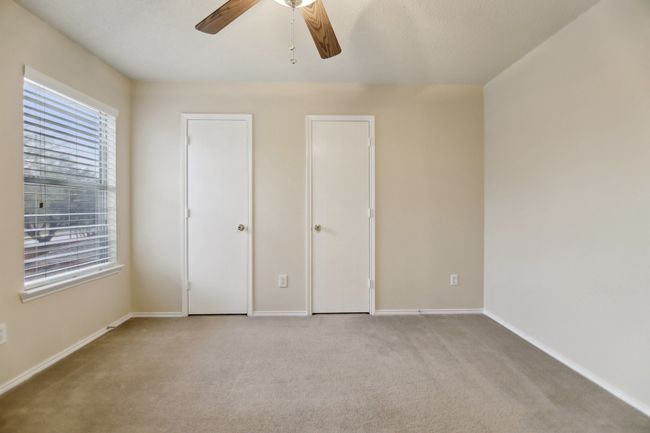 Unfurnished bedroom with light carpet, baseboards, and ceiling fan | Image 29