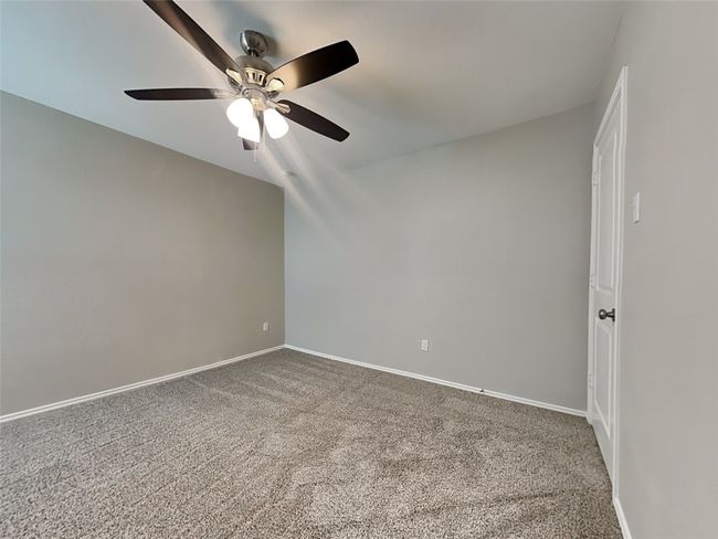 Empty room with a ceiling fan, carpet, and baseboards | Image 7