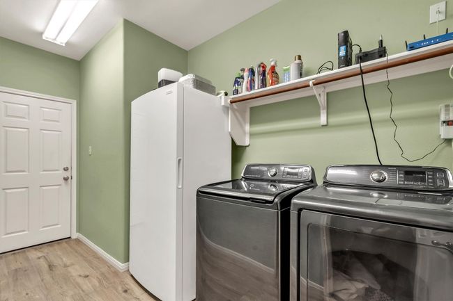 Clothes washing area with washing machine and dryer, light wood-style floors, baseboards, and laundry area | Image 32