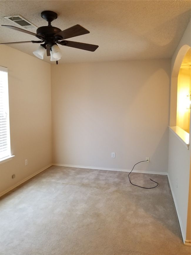 Carpeted empty room with arched walkways, ceiling fan, plenty of natural light, and a textured ceiling | Image 18