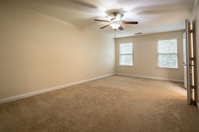 Empty room with light colored carpet and ceiling fan | Image 11
