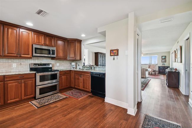 Granite counters and enlarged opening for expansive view from the kitchen. Bamboo flooring throughout. | Image 15
