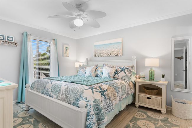 Bedroom featuring wood finished floors, ornamental molding, a ceiling fan, and baseboards | Image 13