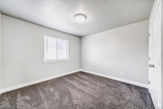 Carpeted spare room featuring baseboards, visible vents, and a textured ceiling | Image 15